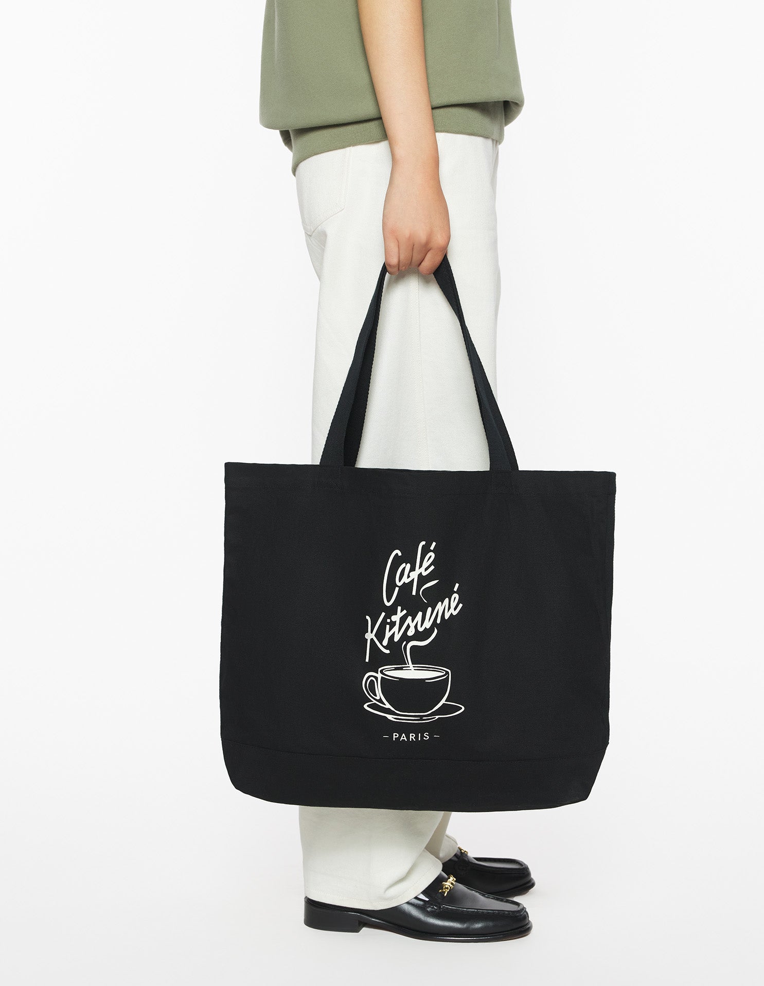 Tote bag Café Kitsuné noir porté à la main, sac cabas lifestyle parisien