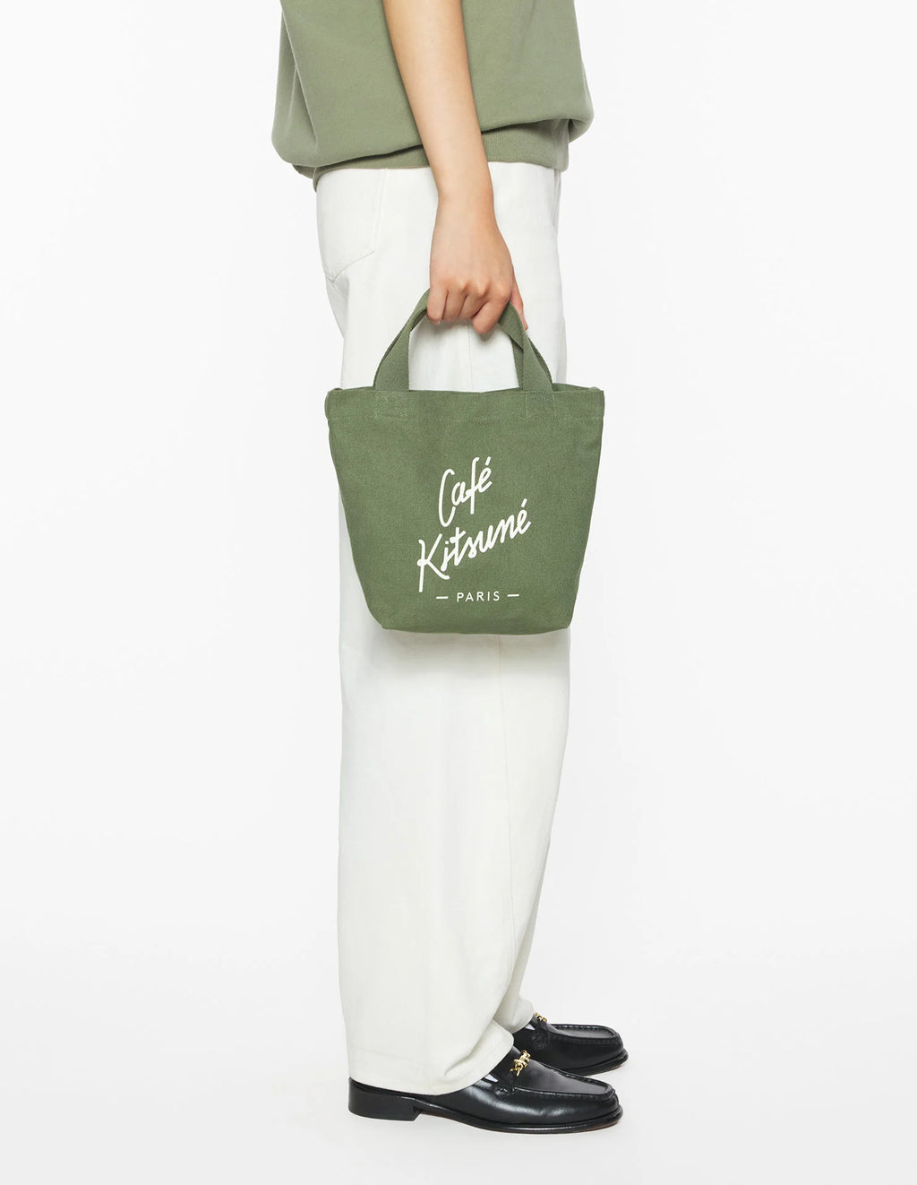 Sac tote Café Kitsuné porté à la main, style lifestyle urbain