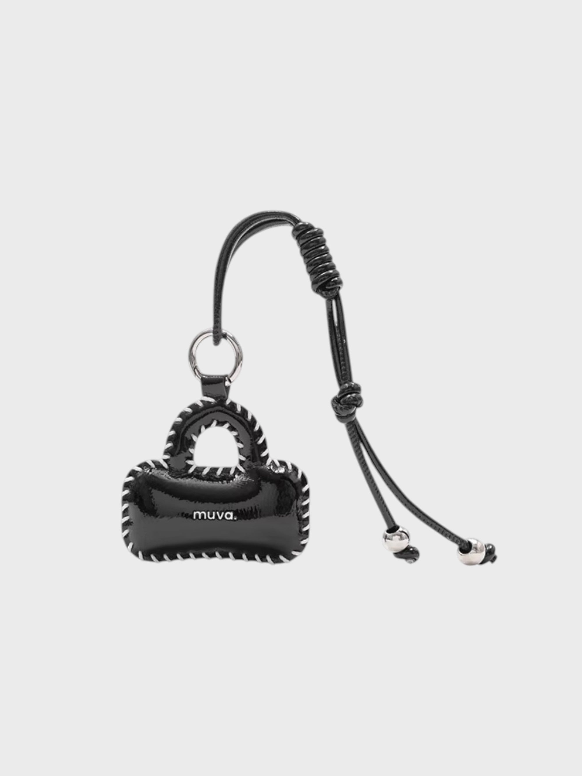 Breloque de sac Boston Bag Wrap MUVA noire sur fond gris clair.