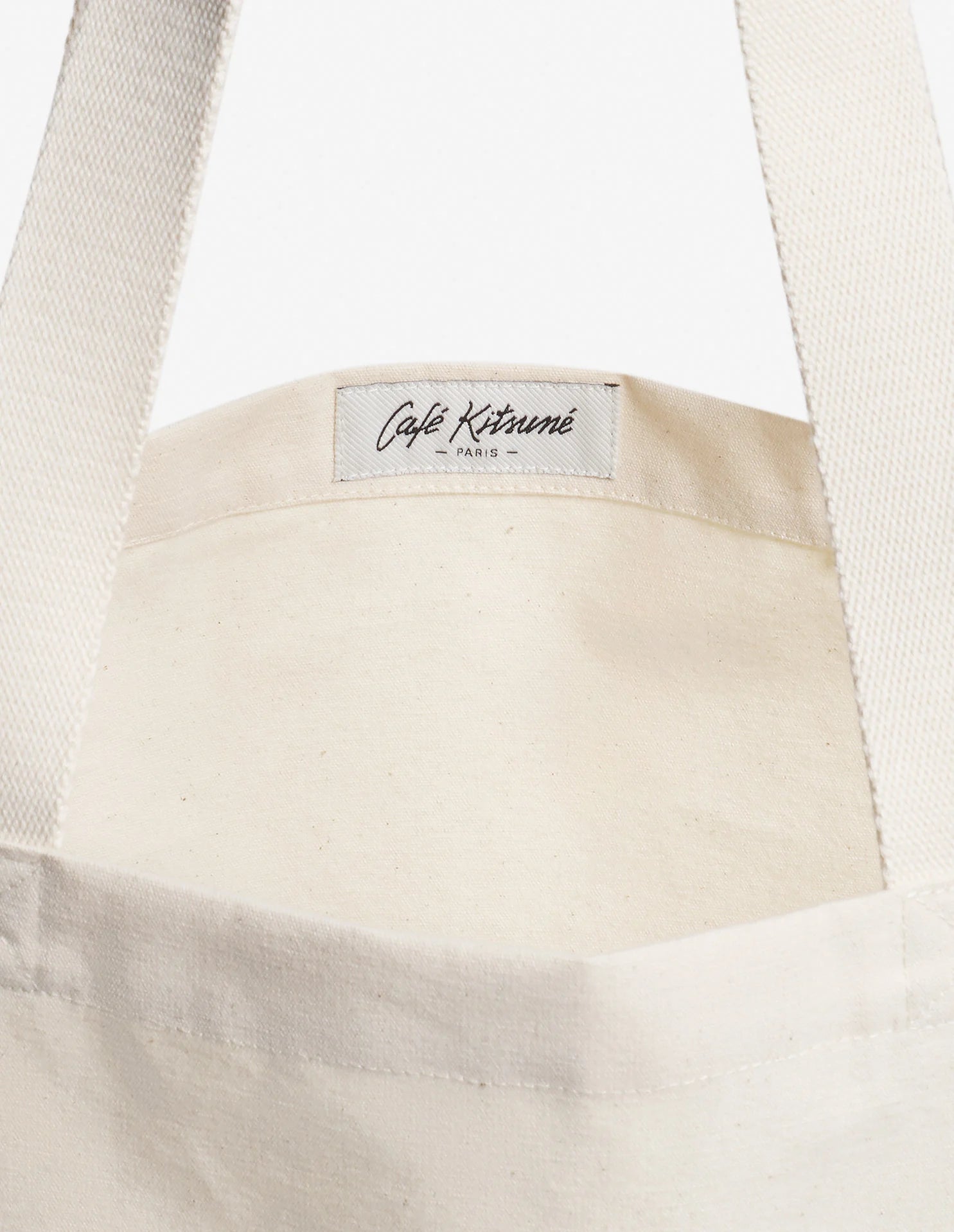 Détail intérieur du sac tote Café Kitsuné avec anses en toile et étiquette logo