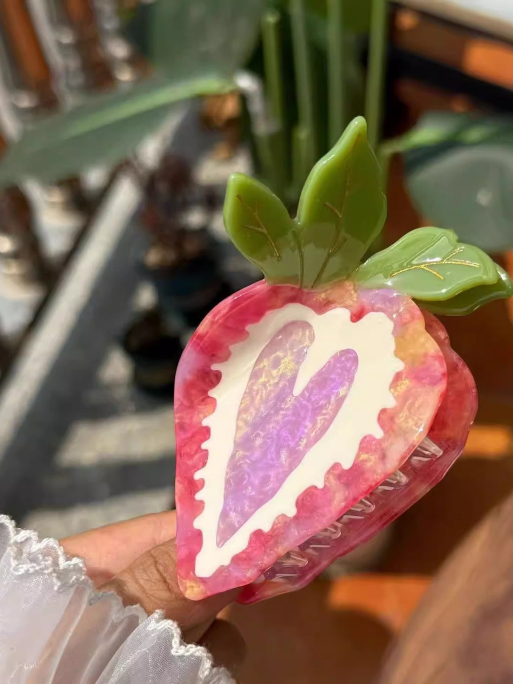 Pince à cheveux en résine DIOIB motif fraise rose et violet avec feuilles vertes, tenue en main
