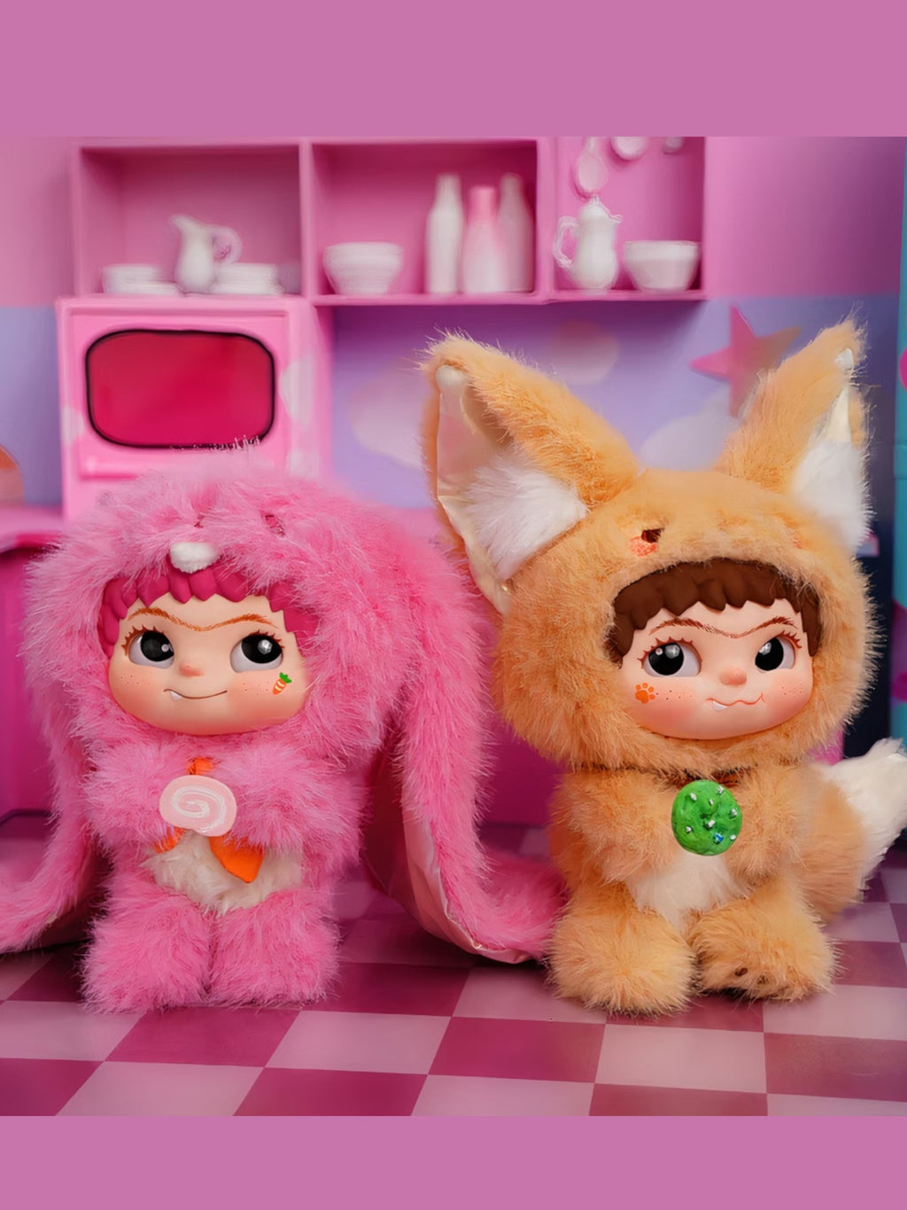 Wakuku duo figurines – deux personnages roses dont un costume renard vert dans une pièce décor dessert et étagères, fond rose
