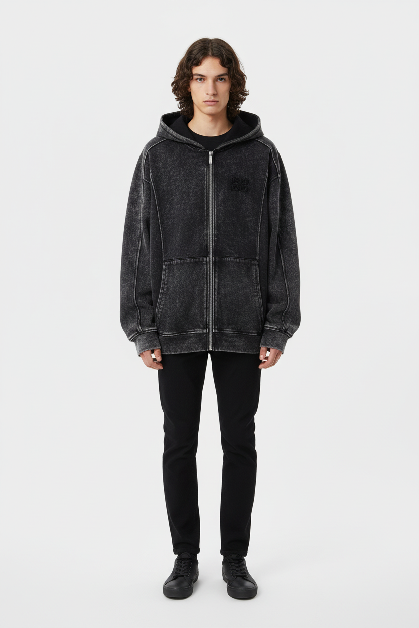 Sweat à capuche zippé oversize BJHG noir délavé avec patch logo, porté par un homme avec jean noir et sneakers noires, vue de face sur fond blanc
