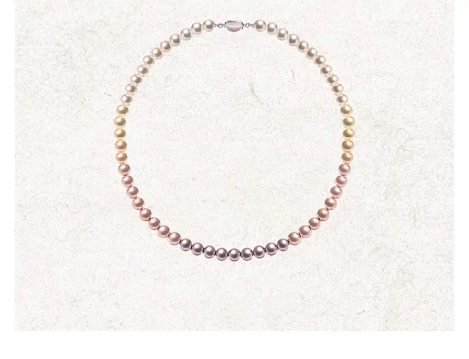 Collier perles dégradé multicolore présenté sur fond neutre, tons pastel doux