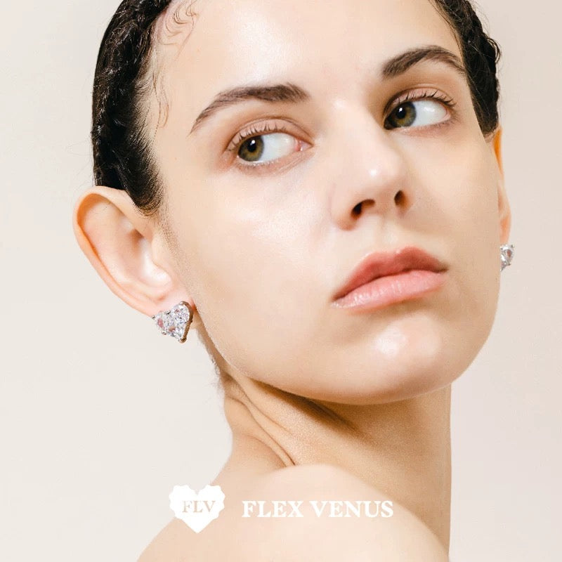 Boucle d’oreille cœur rose en serti doré vue de profil, portée sur l’oreille