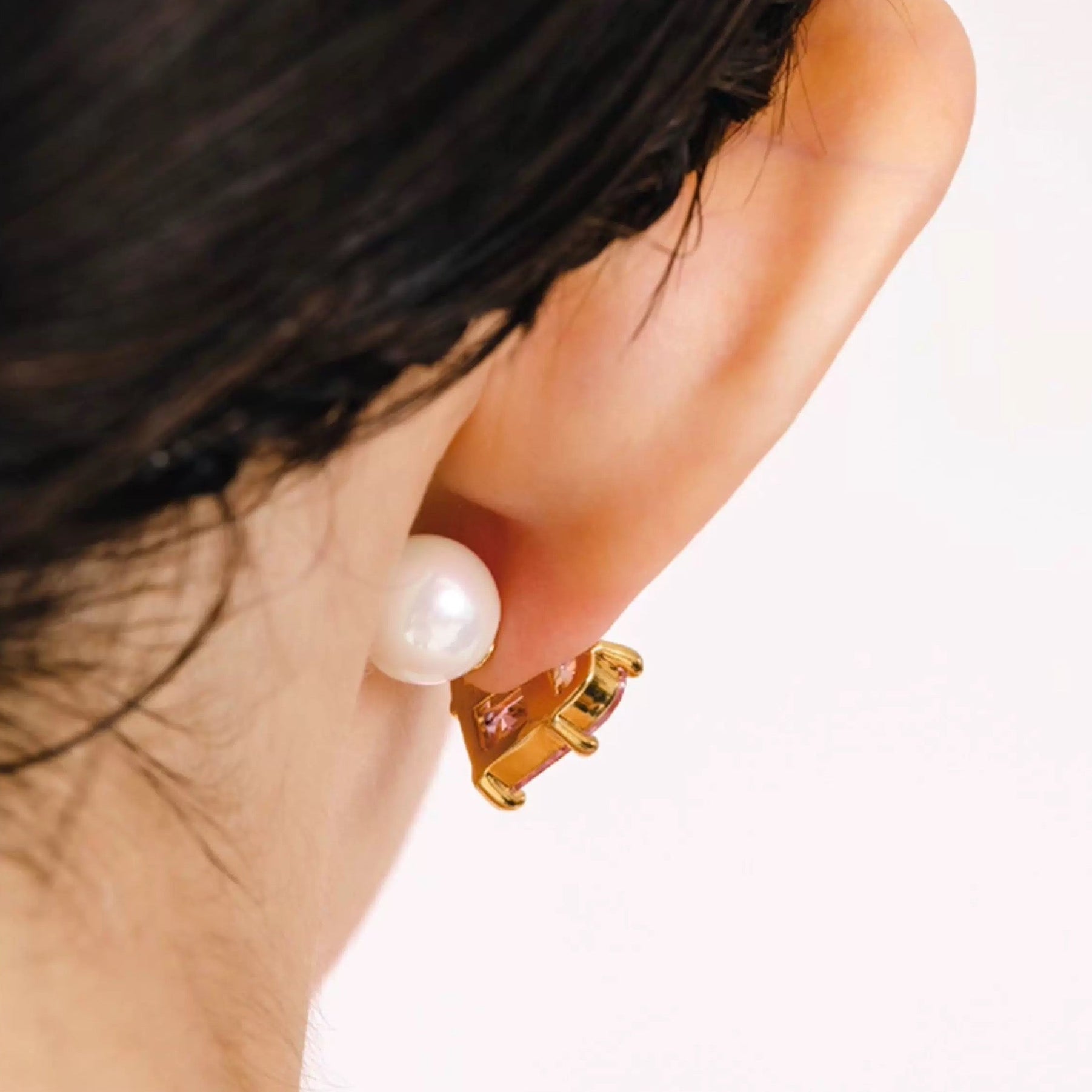 Fermoir perle d’une boucle d’oreille dorée cœur rose, vue arrière portée