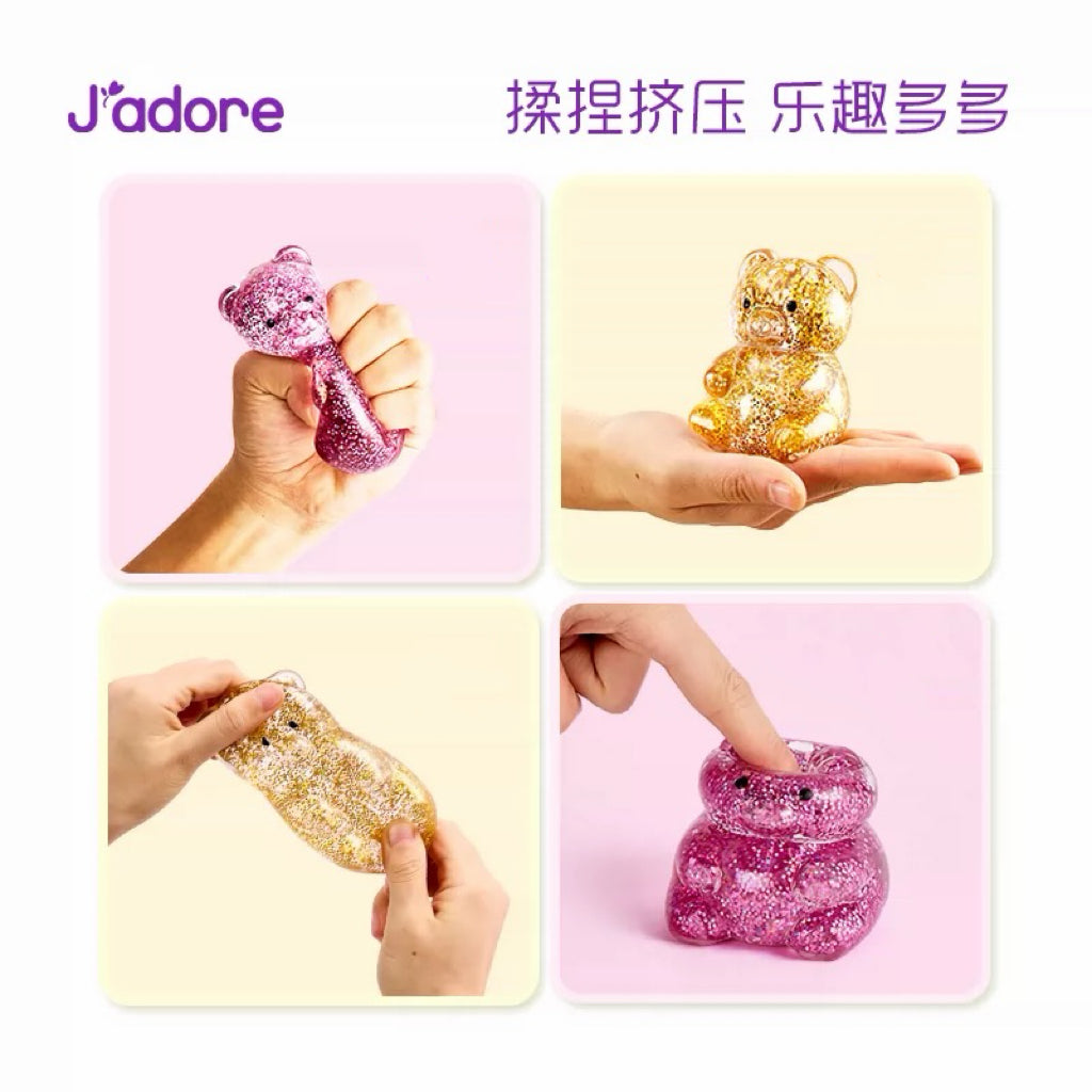 Jouet squishy ours gel pailleté J'adore en 3 gestes : pression du doigt rose, serrage poing rose, étirement doré
