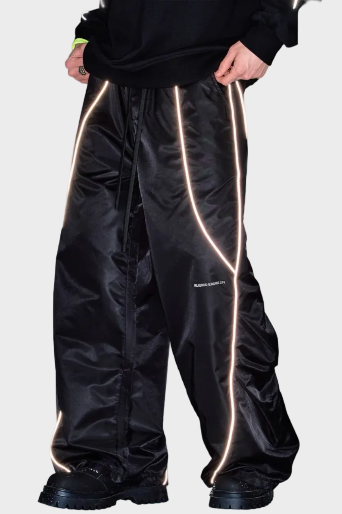 Pantalon large BJHG noir en nylon avec bandes réfléchissantes dorées, porté par un homme, vue de face sur fond gris
