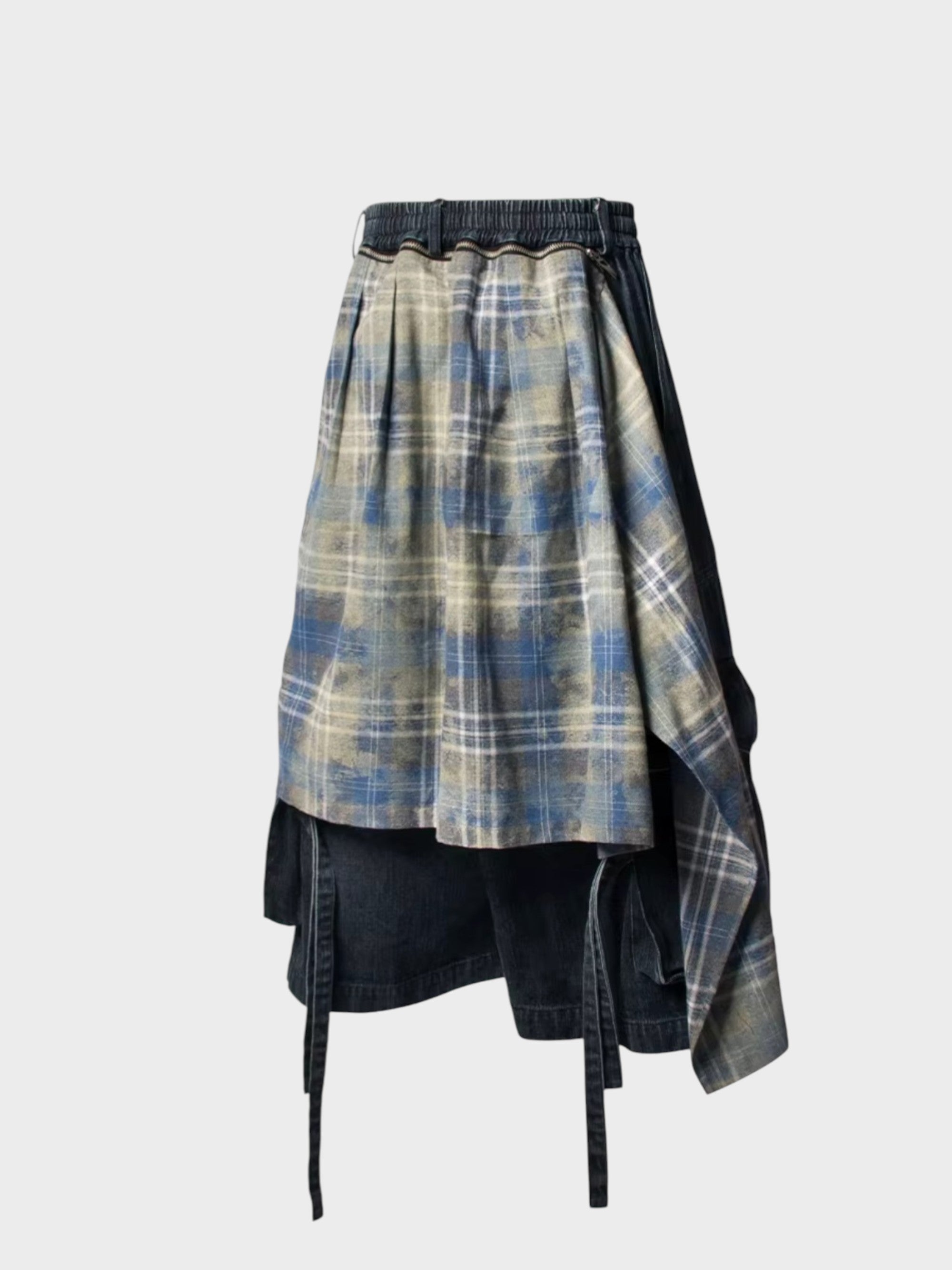 Pantalon RELABEL noir superposé à jupe carreaux bleu asymétrique et sangles, vue de dos sur fond gris
