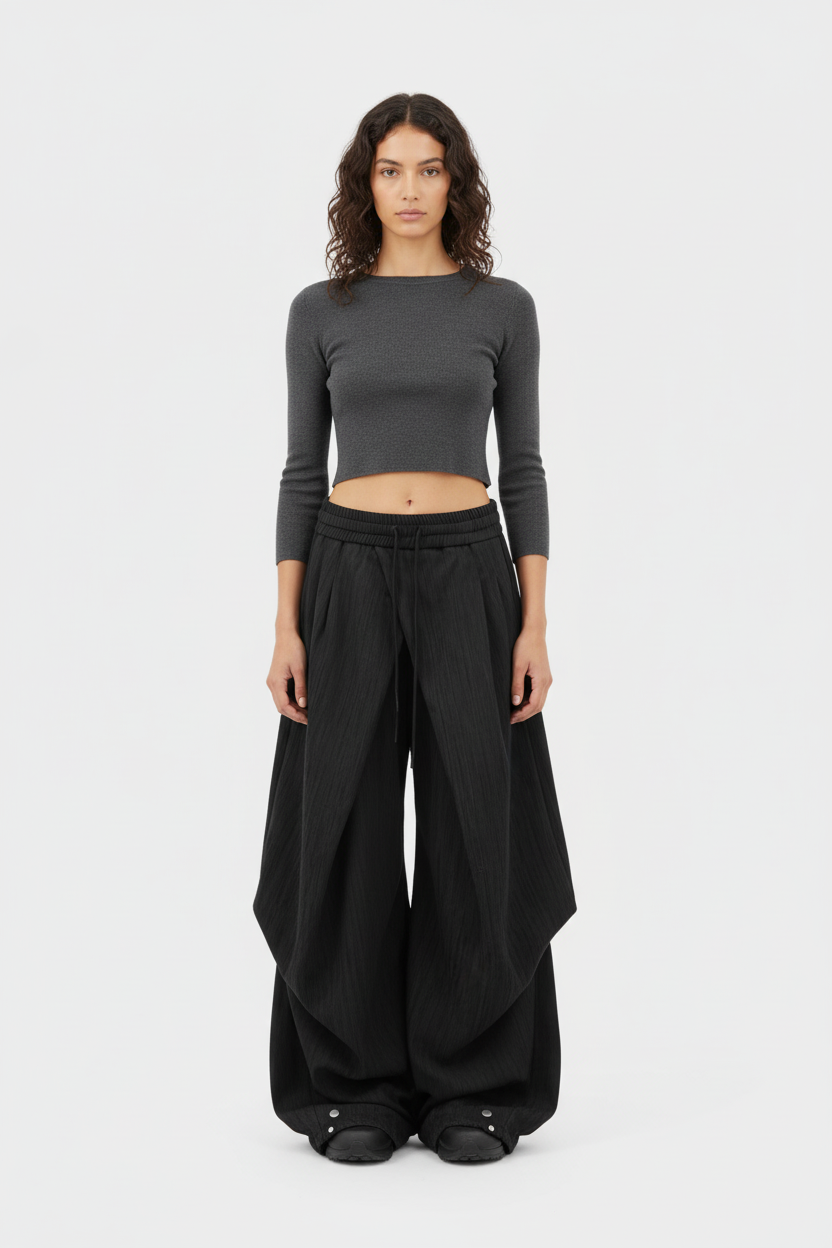 Pantalon RELABEL noir extra large à grands plis taille basse, porté par une femme avec crop top gris, vue de face sur fond blanc
