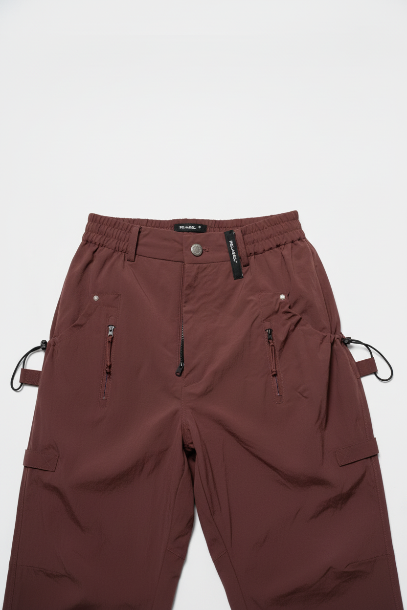 Pantalon cargo marron chocolat multi-poches – 4 poches zippées frontales, cordons ajustables noirs sur les côtés, ceinture élastique bouton métal, étiquette noire logo, coupe droite unisexe, vue de face, fond blanc