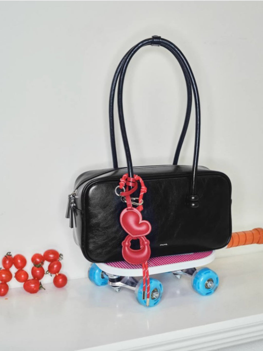 Sac Boston perlé MUVA noir en cuir, photo lifestyle avec détail de breloque
