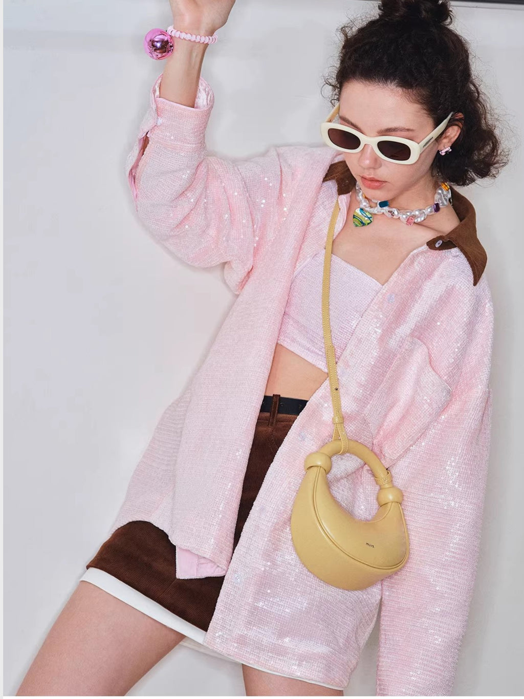 Sac demi-lune MUVA jaune crème porté en bandoulière, photo lifestyle