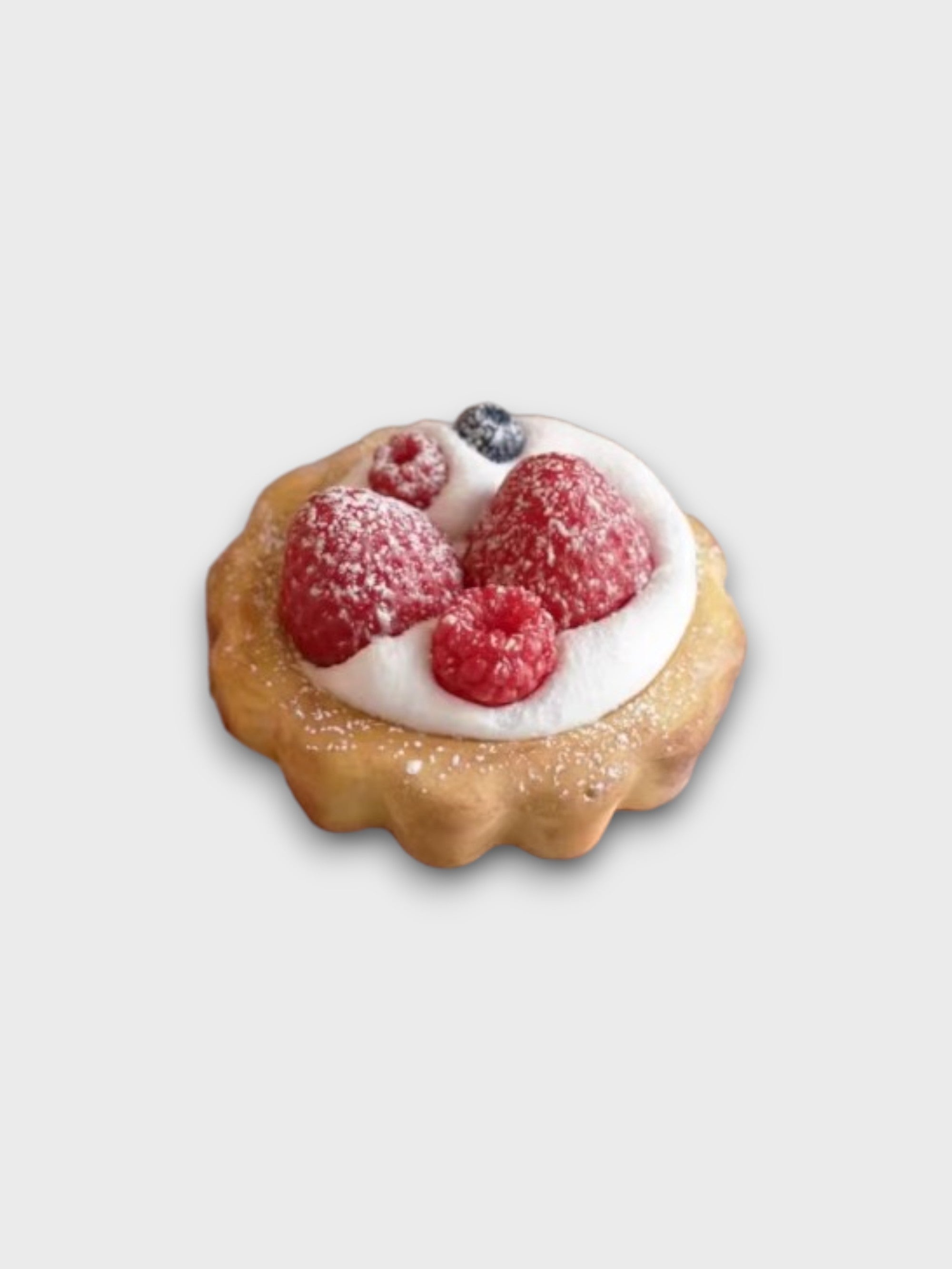 Savon artisanal Sweetlab en forme de tarte aux framboises et myrtille sur crème chantilly, vue de dessus sur fond gris
