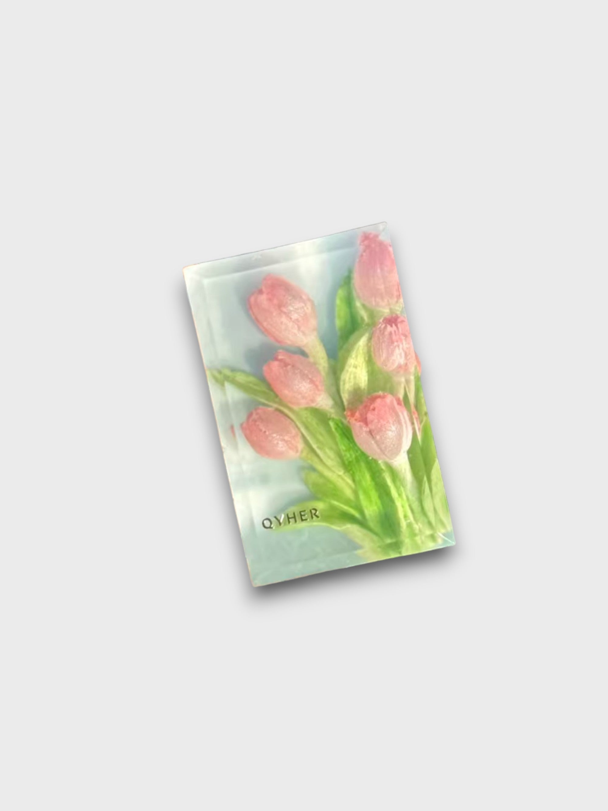 Savon artisanal QYHER motif bouquet de tulipes roses sur fond vert d'eau, vue de dessus inclinée sur fond gris
