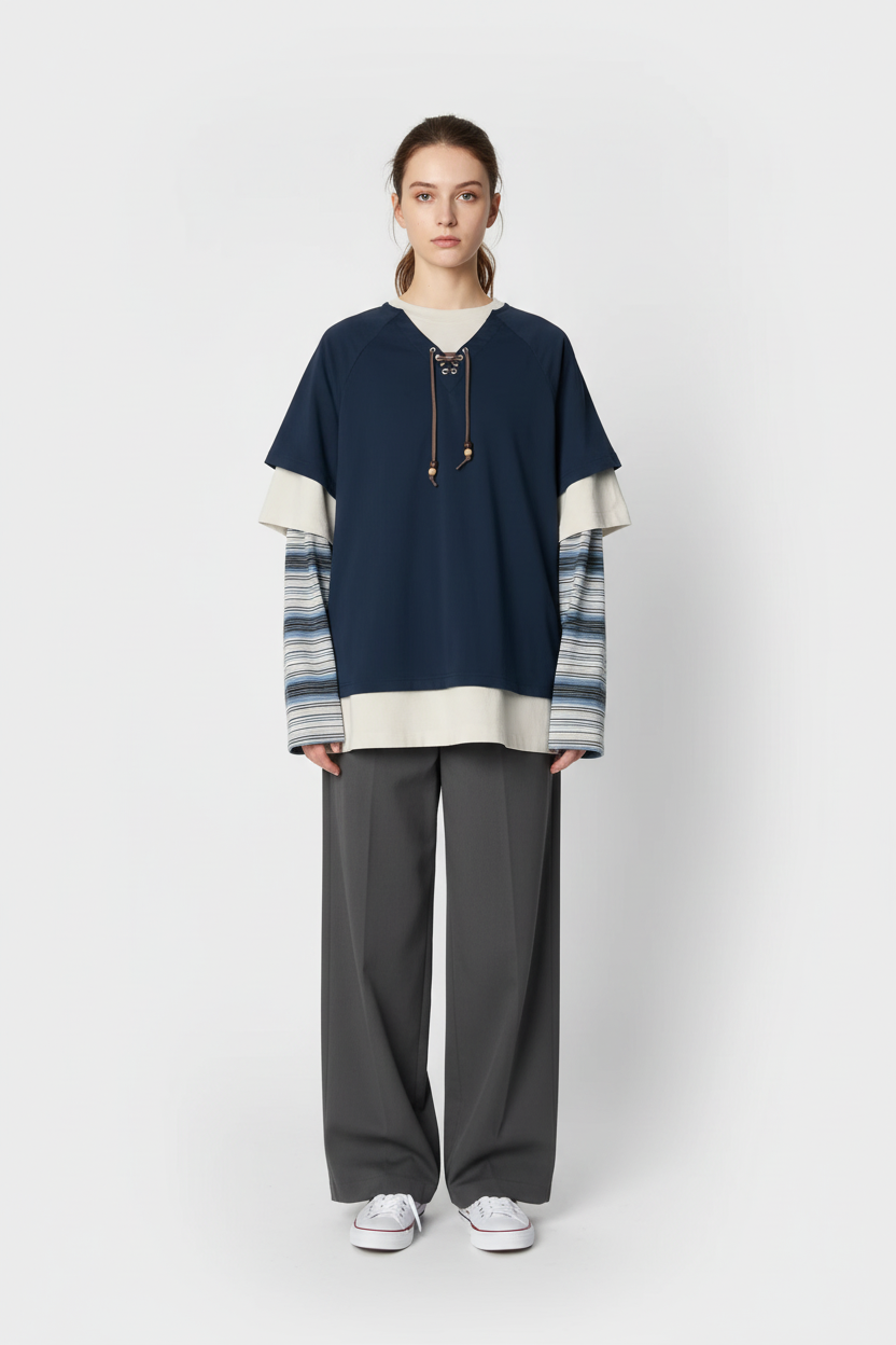 T-shirt RELABEL bleu marine oversize à col lacets avec manches longues rayées superposées, porté par une femme, vue de face sur fond blanc
