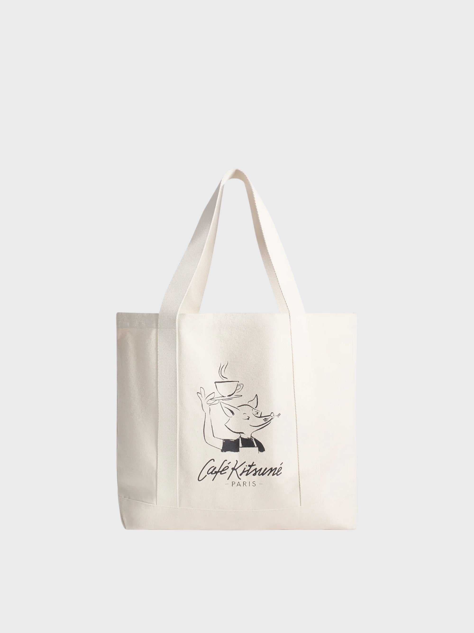 Tote bag Café Kitsuné écru en toile avec illustration renard serveur tenant une tasse de café et texte Café Kitsuné Paris, fond gris clair
