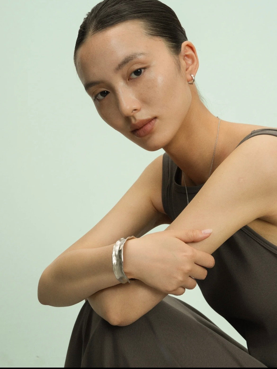 Bracelet jonc martelé Freddo argenté en argent sterling, porté par une femme en studio, vue de trois quarts