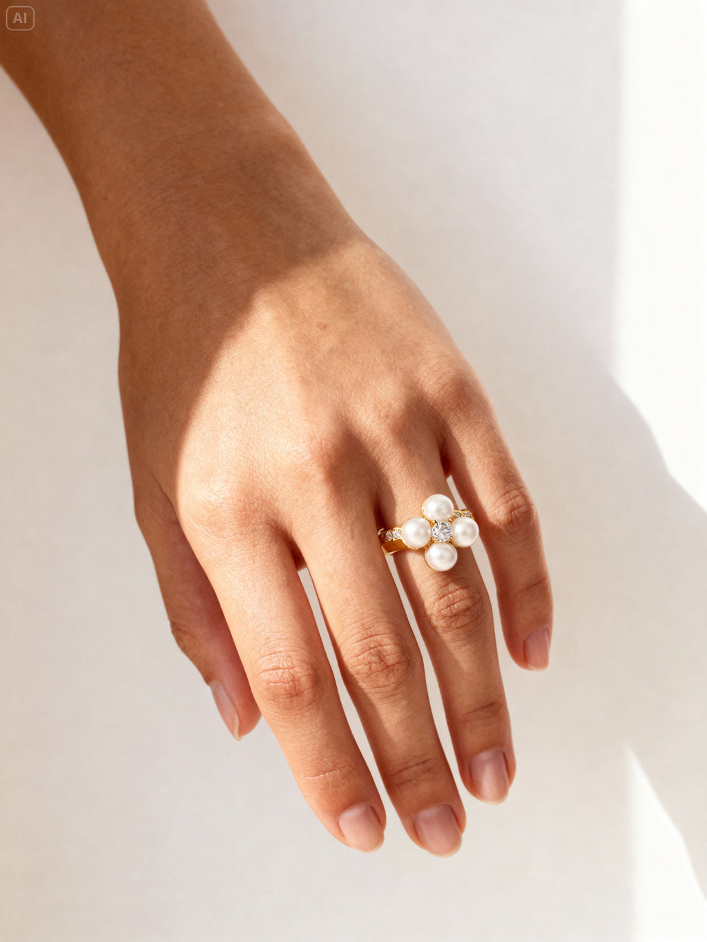 Bague dorée fleur en perles portée sur la main, style chic et féminin