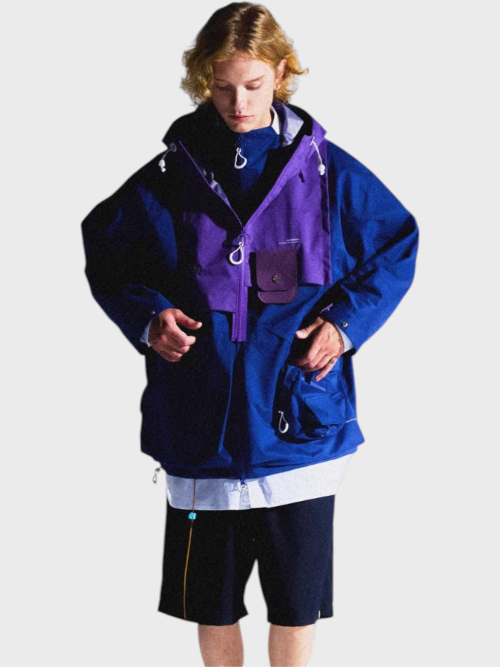 Veste outdoor imperméable Eafinetal bicolore bleu et violet avec capuche et poches multiples, portée par un homme, vue de face
