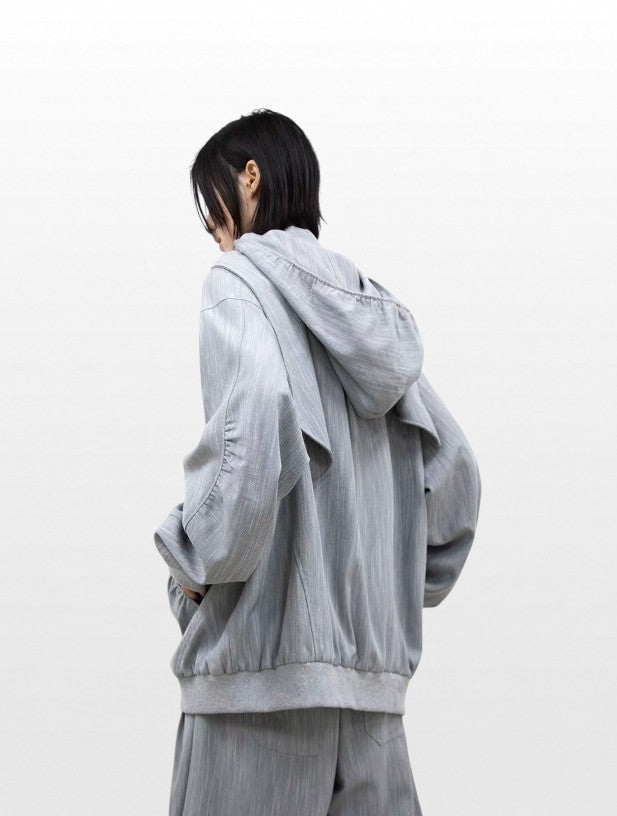 Hoodie zip capuche oversize RELABEL gris chiné porté par une femme, vue de dos avec capuche drapée et jogging large gris assorti
