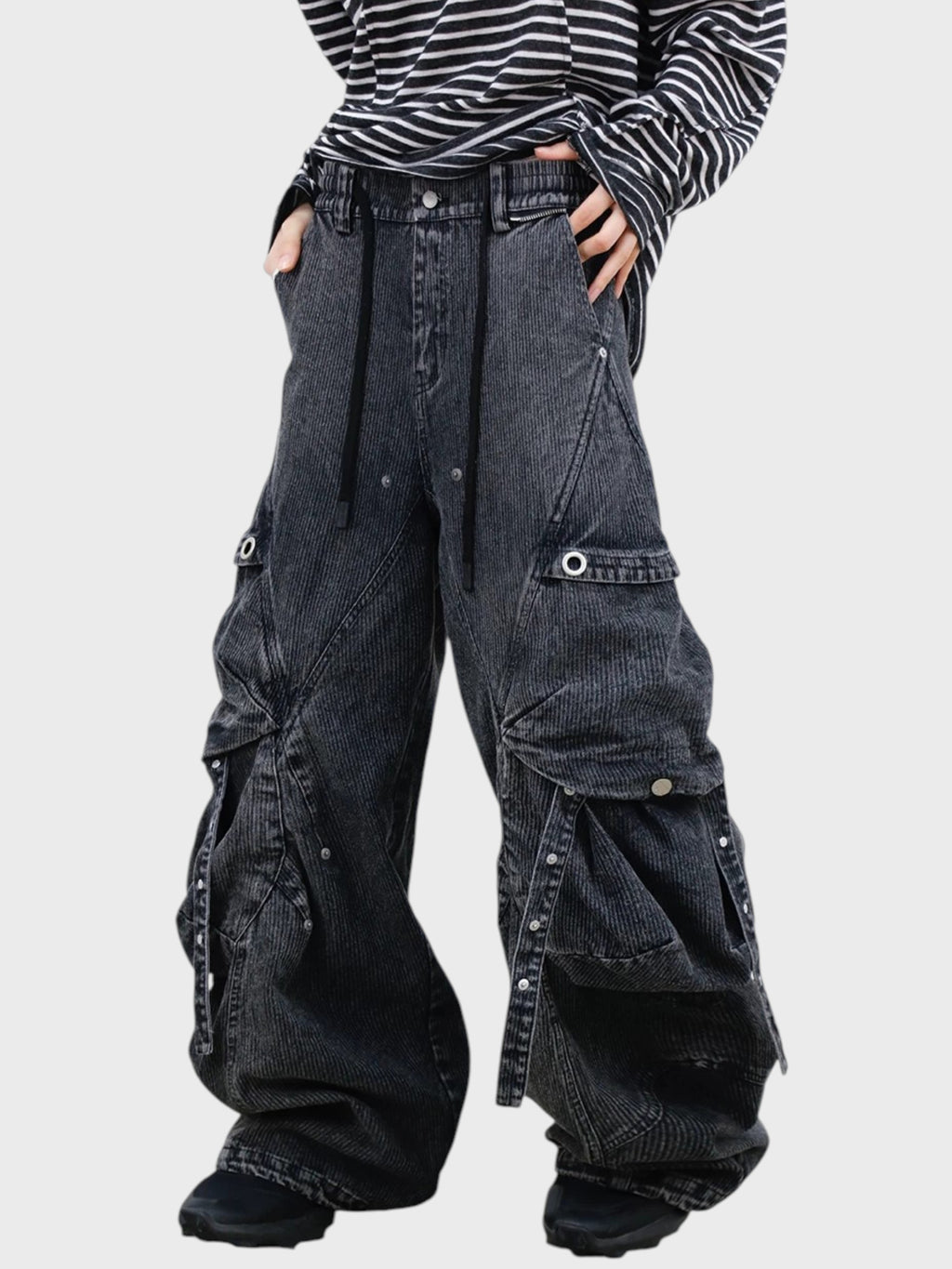 Jean cargo large RELABEL gris rayures washed porté par une femme, gros plan sur les poches volumées gouttes d'eau et œillets argentés avec t-shirt rayé noir blanc

