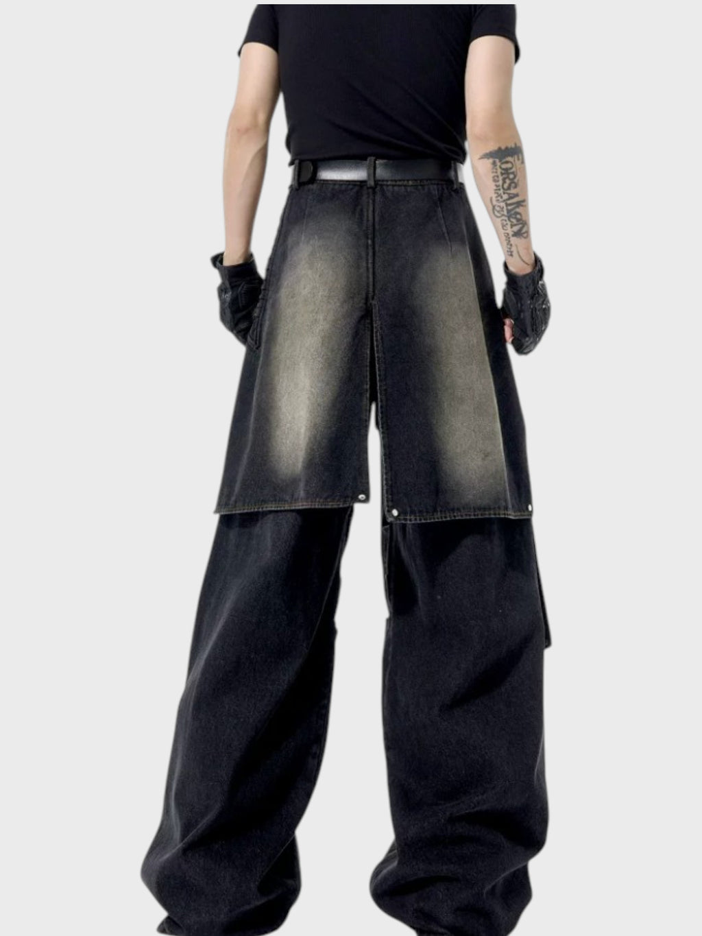 Jean oversize STARTEXCEEDEND double couche denim porté par un homme, jupe-tablier washed kaki ouverte sur pantalon noir en dessous, avec t-shirt noir et ceinture cuir, vue de face
