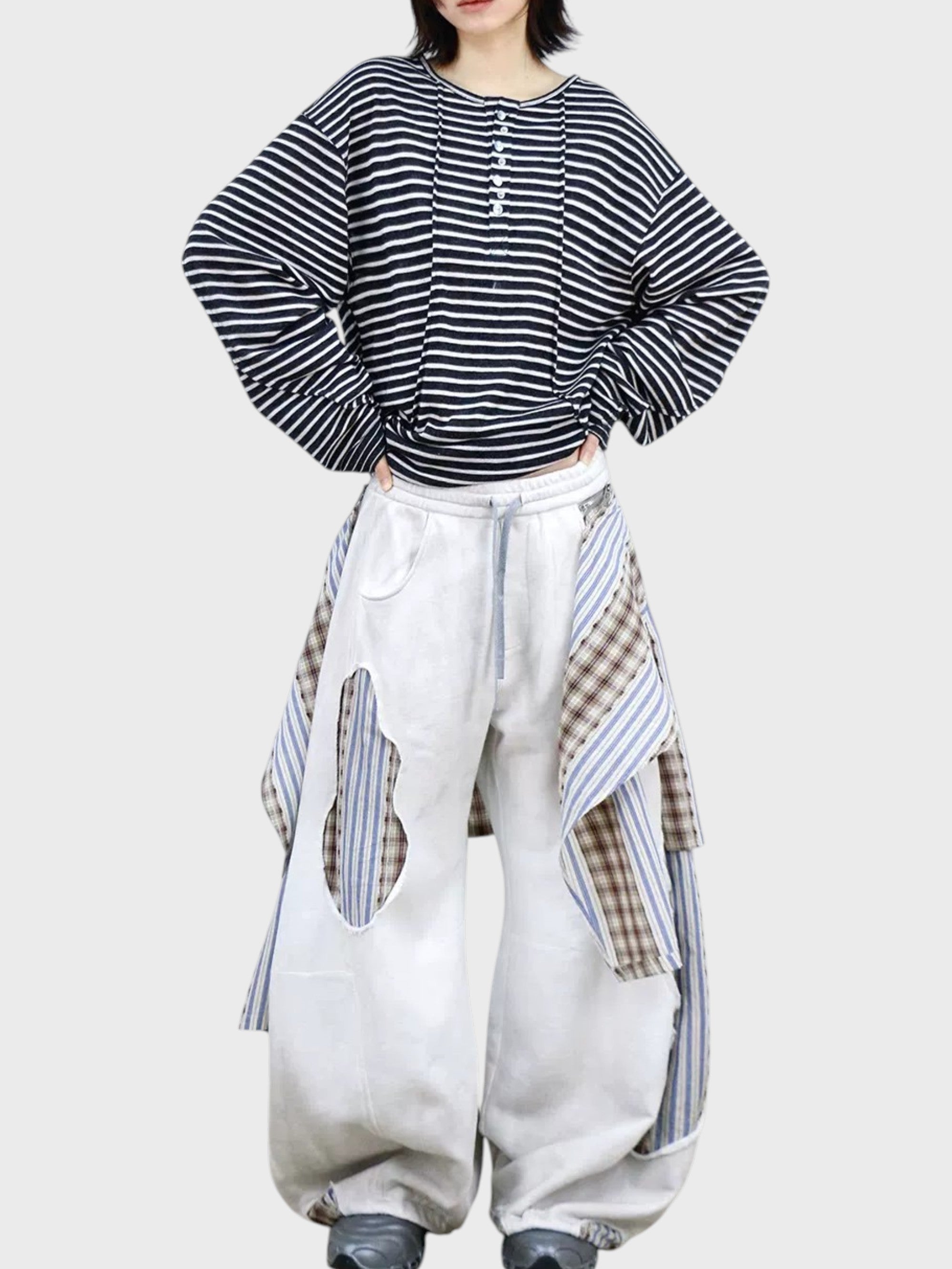 Jogging large RELABEL blanc patchwork porté par une femme, vue de face avec t-shirt rayé marine et chaussures grises
