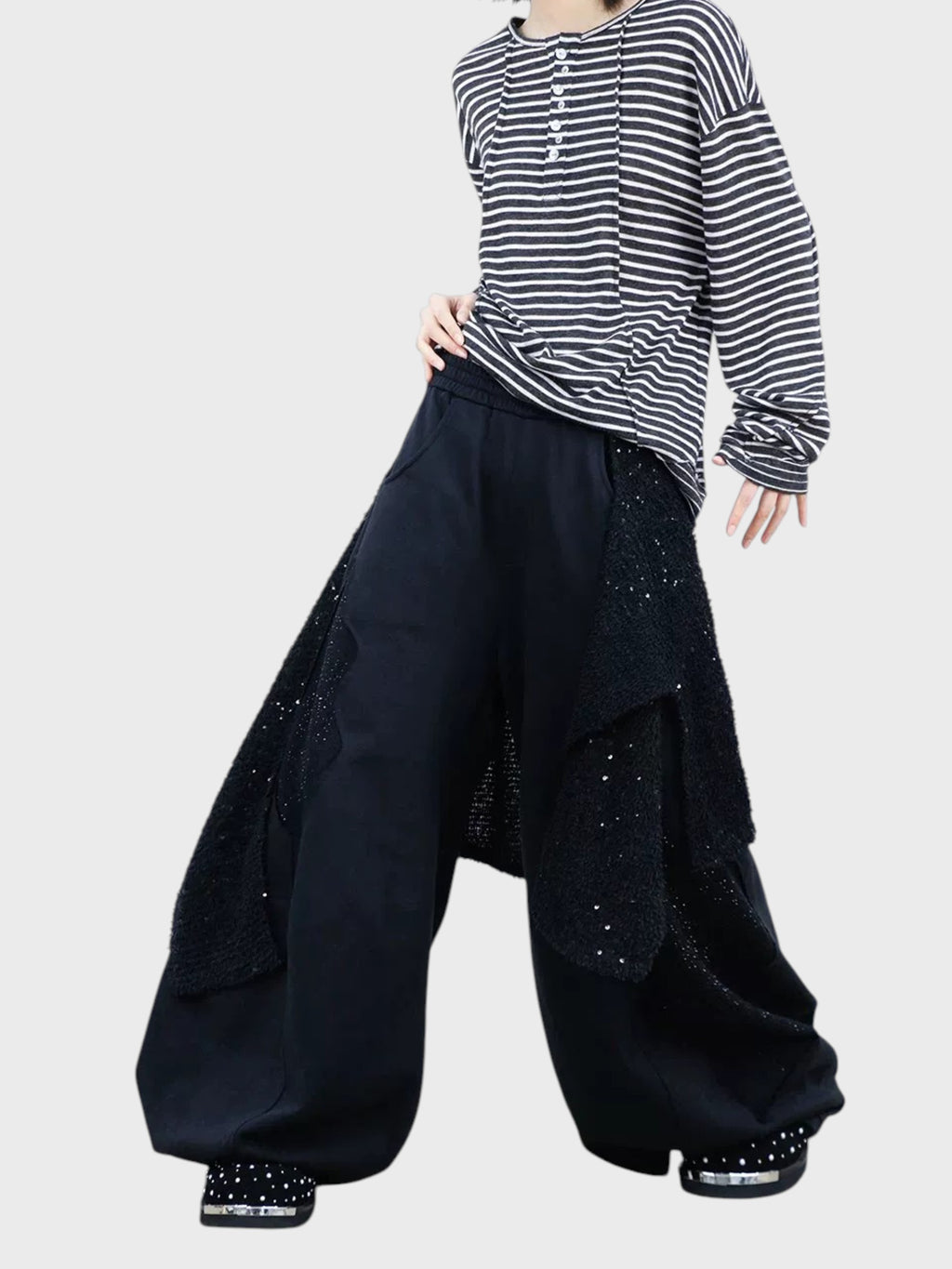 Jogging large RELABEL noir strass porté par une femme, vue de face avec t-shirt rayé et chaussures strass
