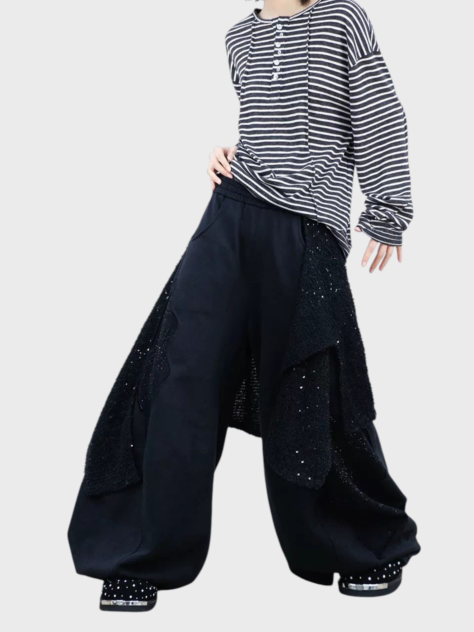 Jogging large RELABEL noir strass porté par une femme, vue de face avec t-shirt rayé et chaussures strass
