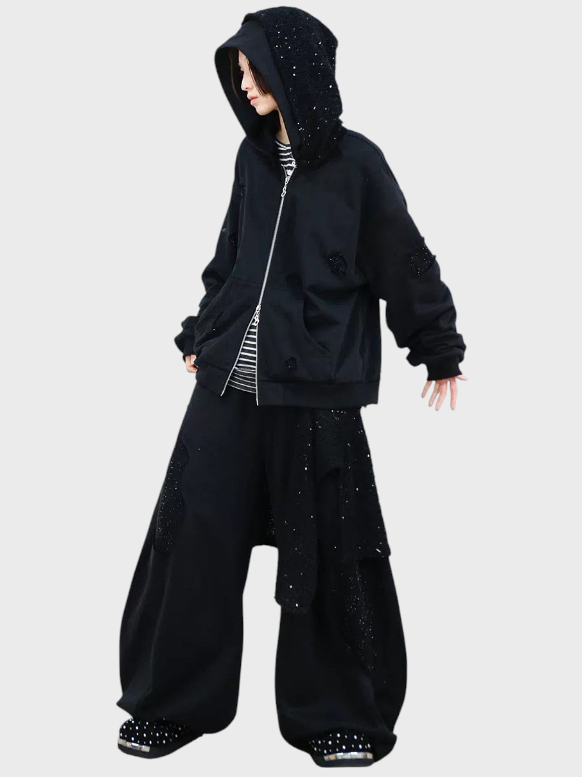 Jogging large RELABEL noir strass porté par une femme, look complet avec hoodie zip strass noir et t-shirt rayé
