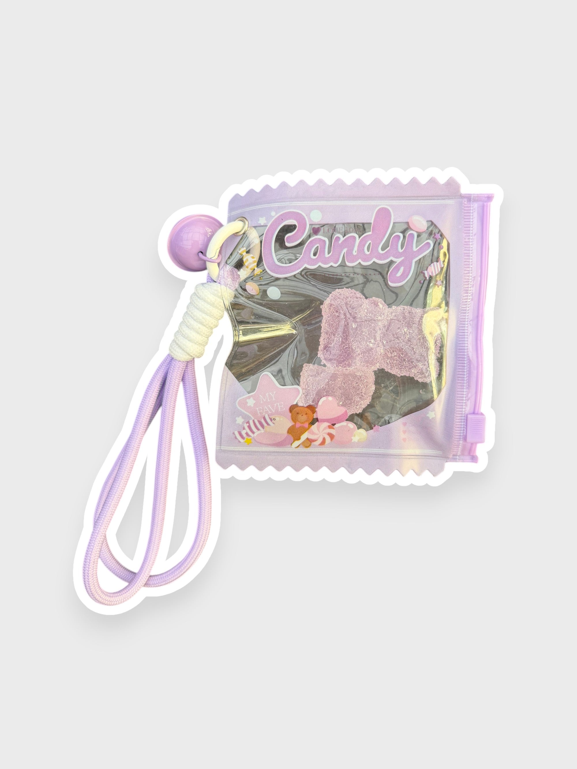 Jouet anti-stress ourson gélifiant raisin recouvert de sable scintillant rose-violet givré dans sachet transparent violet lavé iridescent forme bonbon Candy lettrage violet pastel avec lanterne cordon violet dégradé et perle violette, fond gris