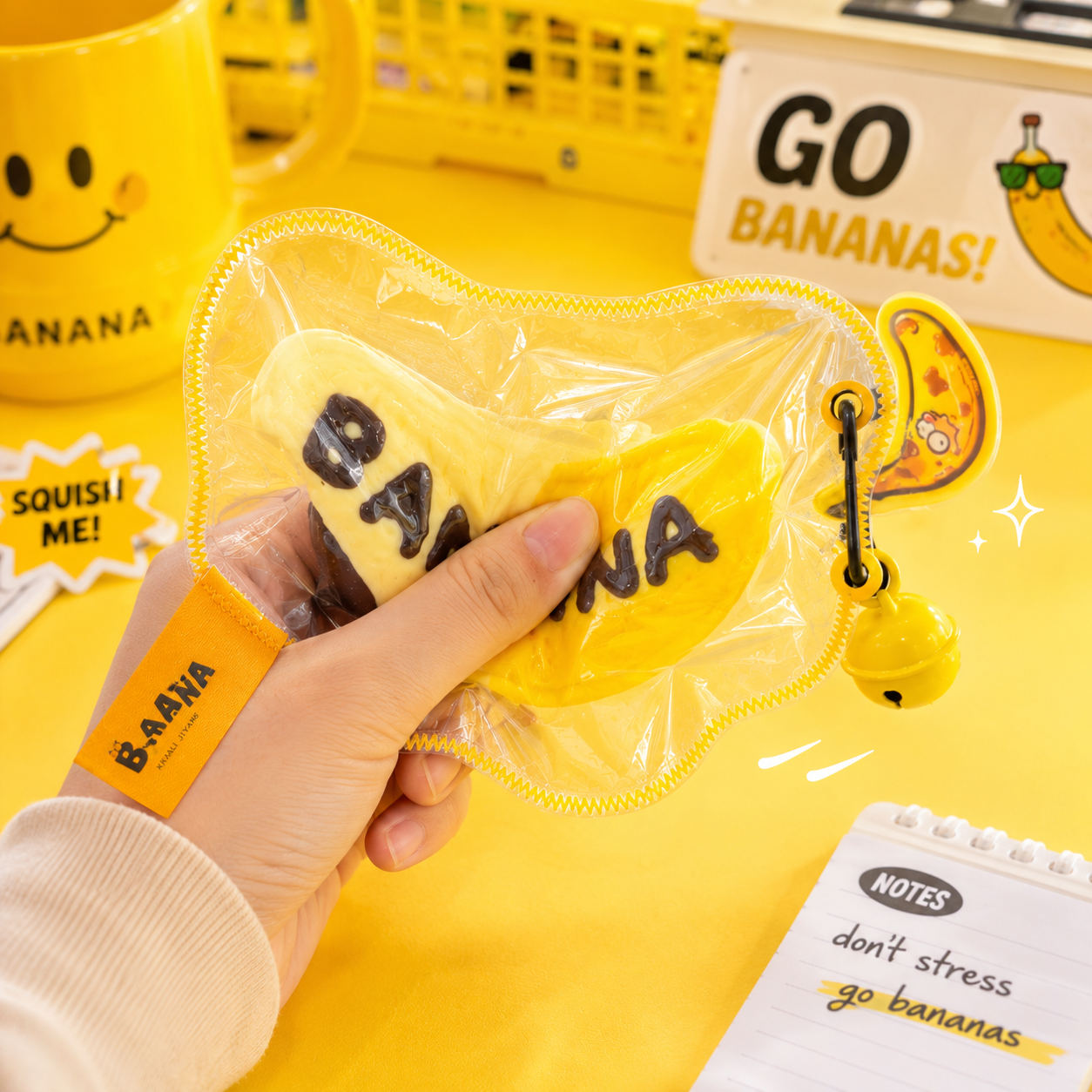 Jouet squishy mousse souple Crazy Gugu jaune polyuréthane banane B-AANA, main pressant le squishy scène go bananas fond jaune