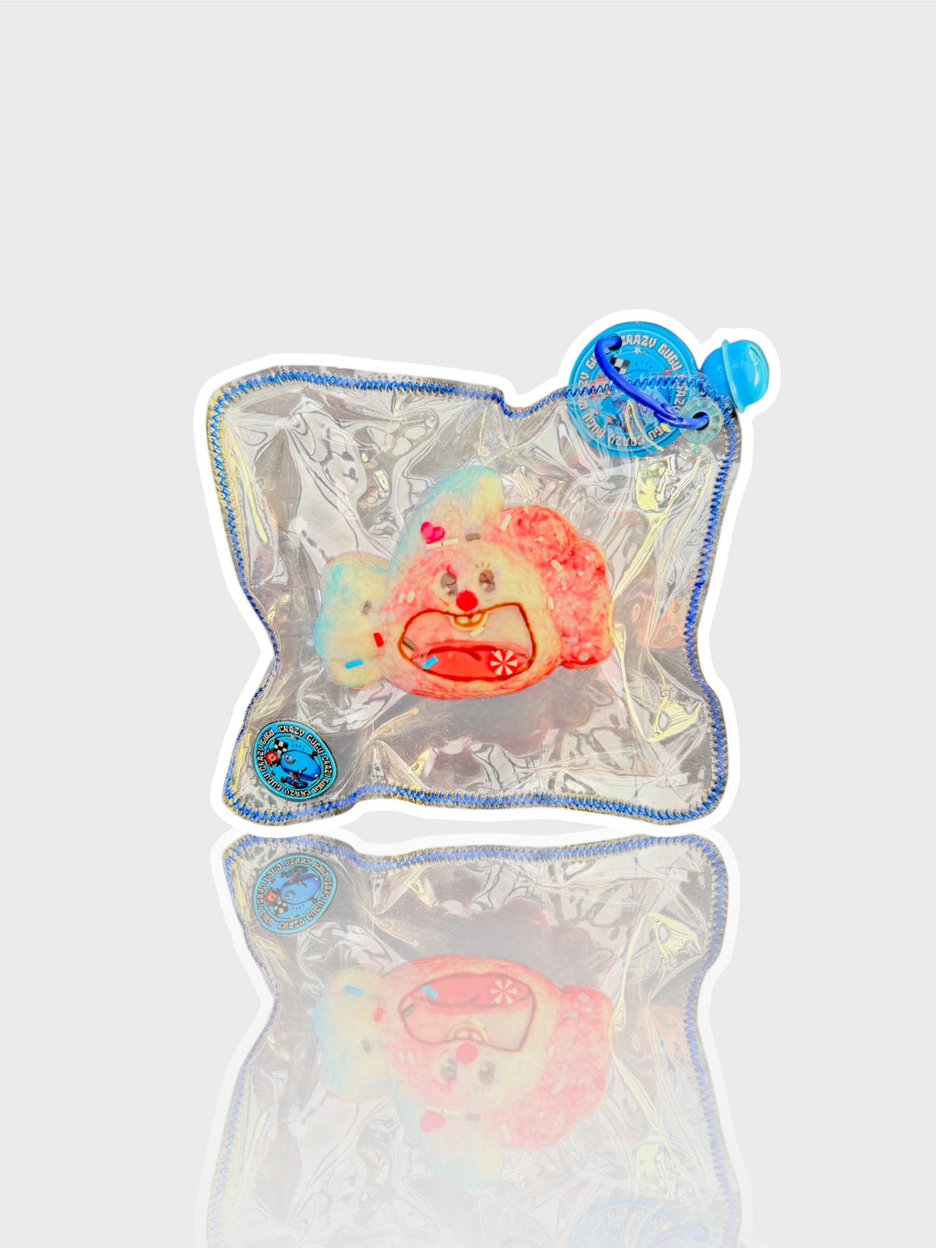 Jouet squishy mousse souple Crazy Gugu rose et bleu polyuréthane, vue de face dans emballage holographique fond blanc