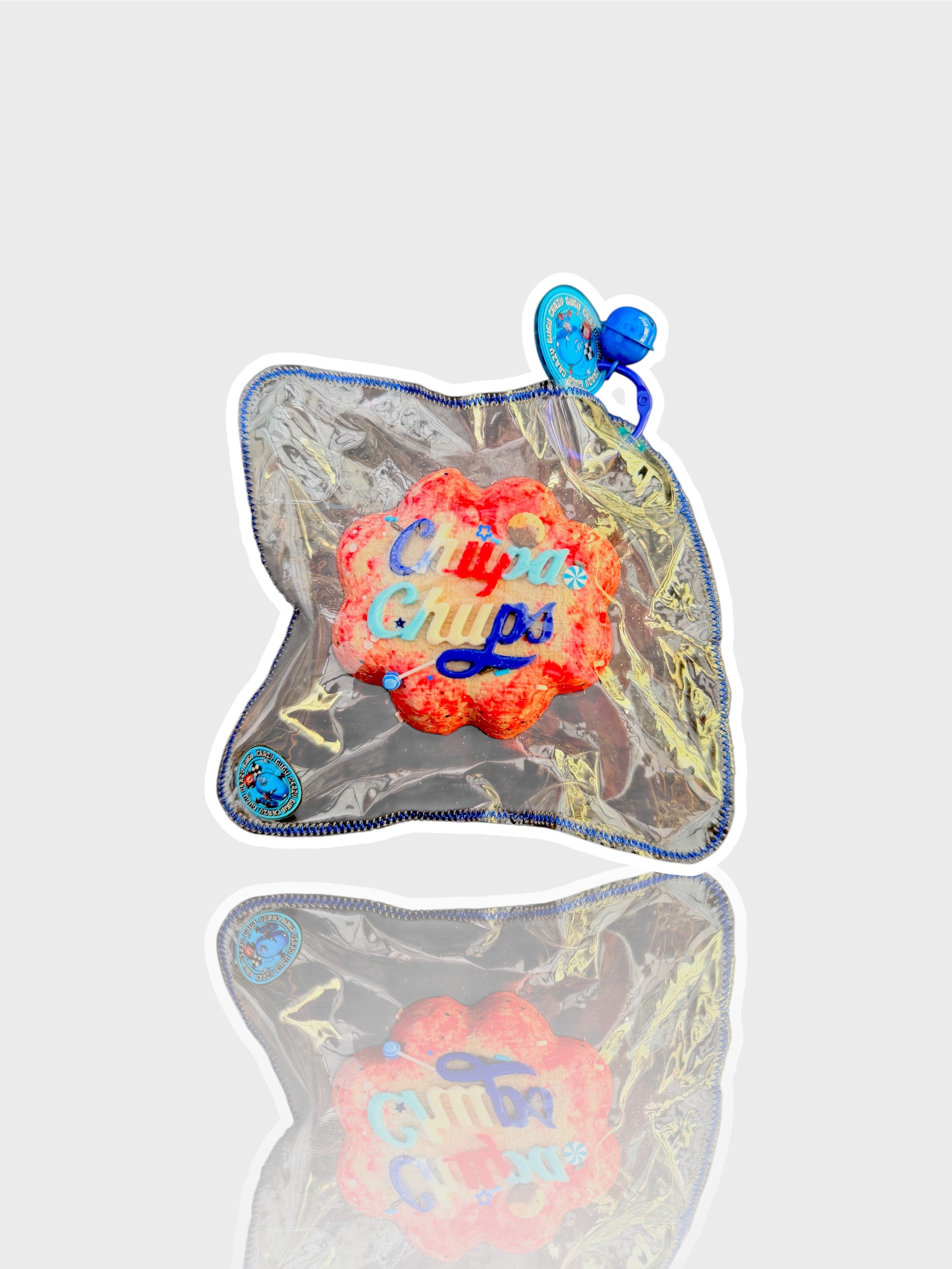Jouet squishy mousse souple Crazy Gugu rouge et rose polyuréthane logo Chupa Chups, vue de face dans emballage holographique fond blanc