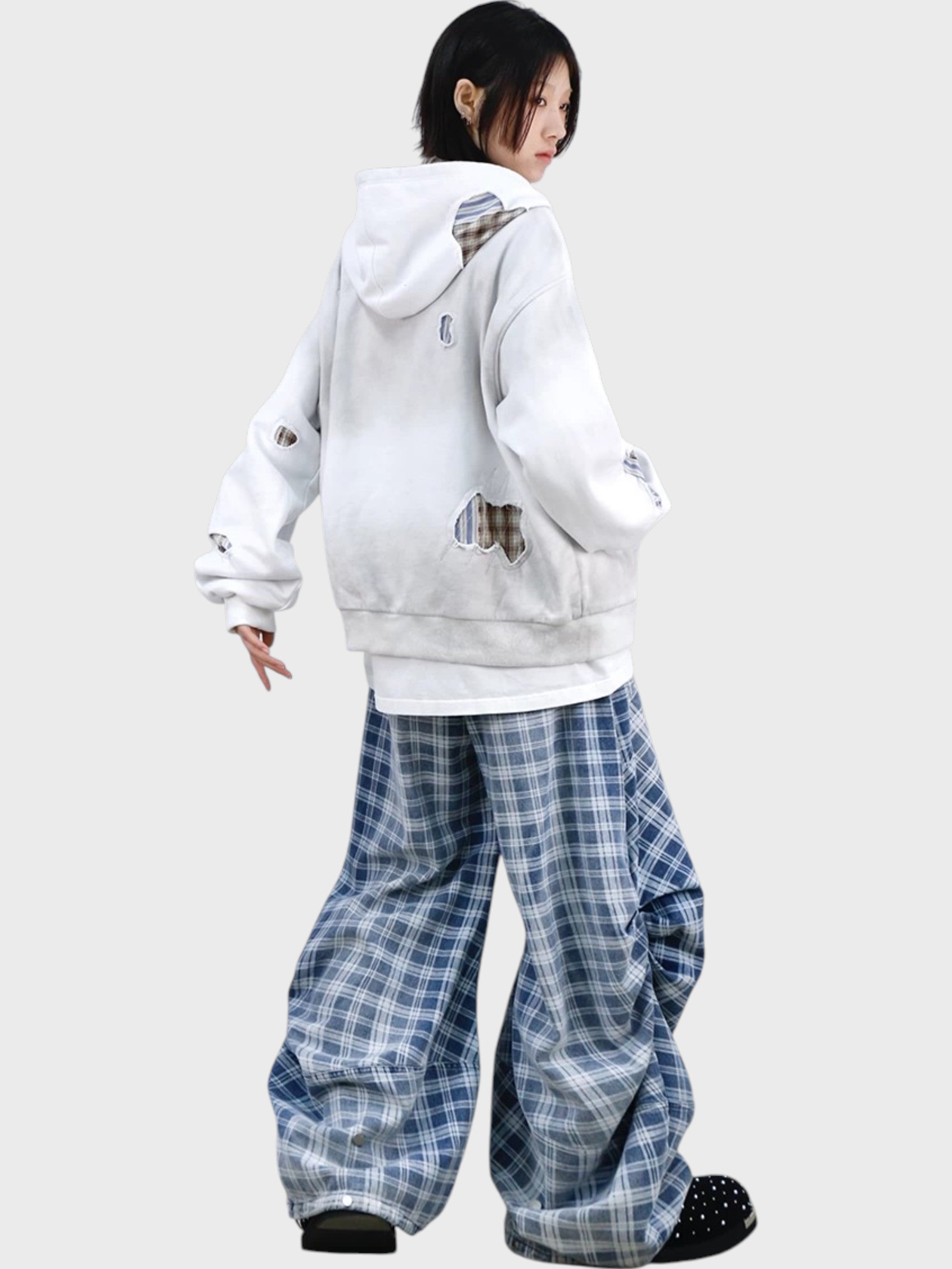 Pantalon ballon RELABEL carreaux bleu gris porté par une femme, vue de dos avec hoodie zip blanc déchiré et sneakers à pois noirs

