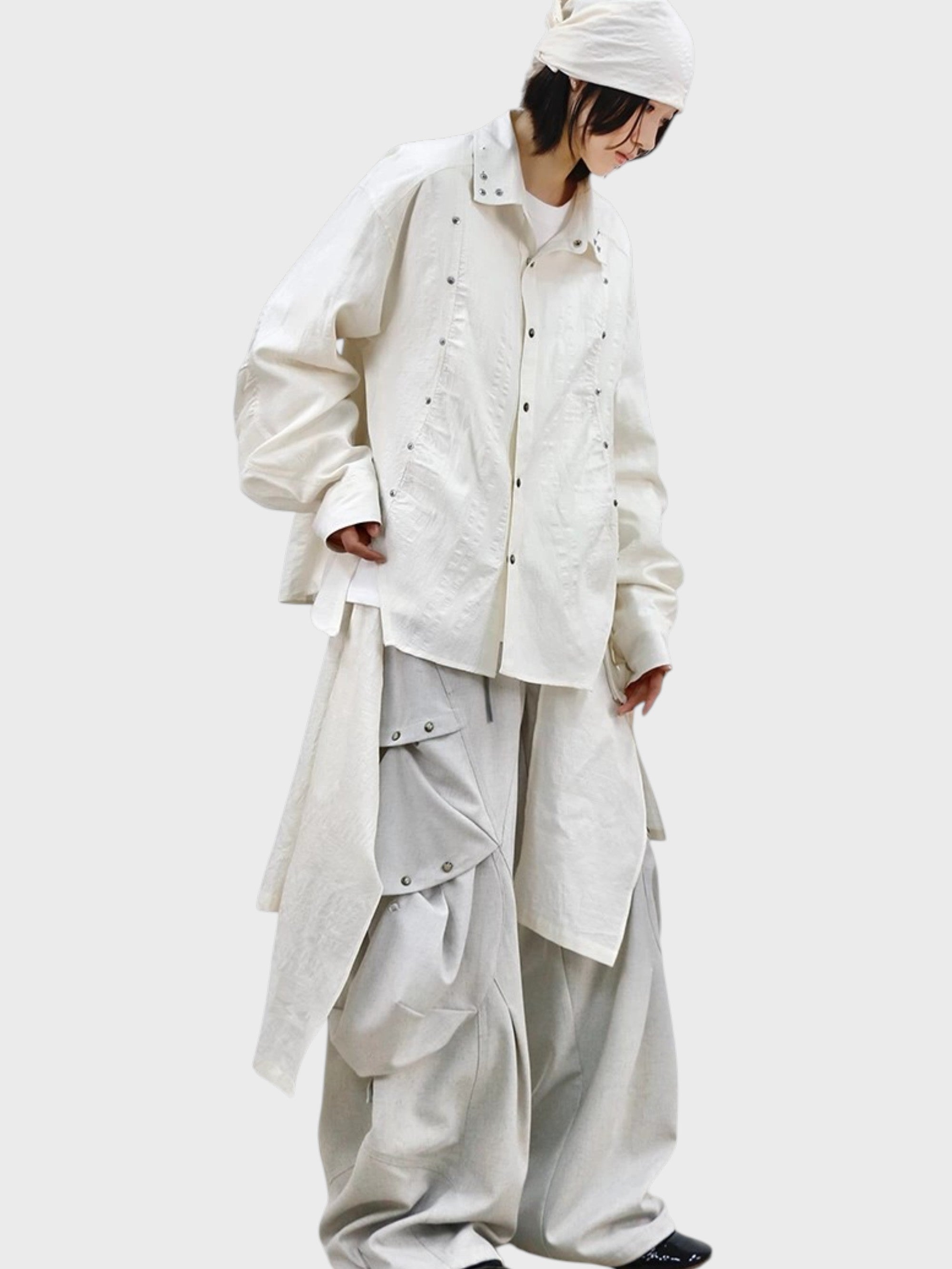Pantalon déconstructiviste RELABEL porté par une femme, look complet avec veste blanche boutons-pression et bonnet blanc
