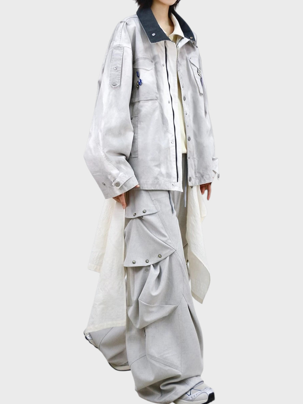 Pantalon déconstructiviste RELABEL porté par une femme de profil, avec veste M65 washed et poches cargo amovibles
