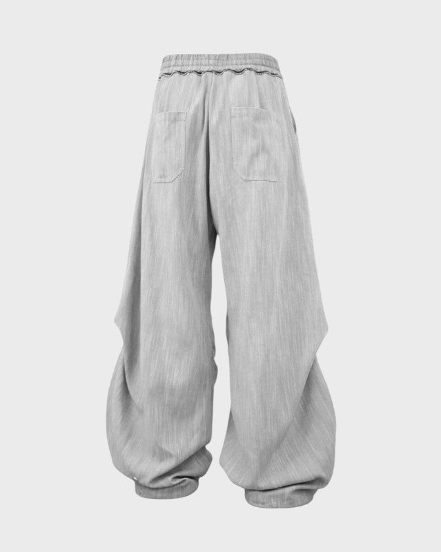 Pantalon oversize Relabel lyocell gris perle avec deux poches dos patch, taille élastique ondulations et ourlet ballon structuré, vue de dos fond blanc