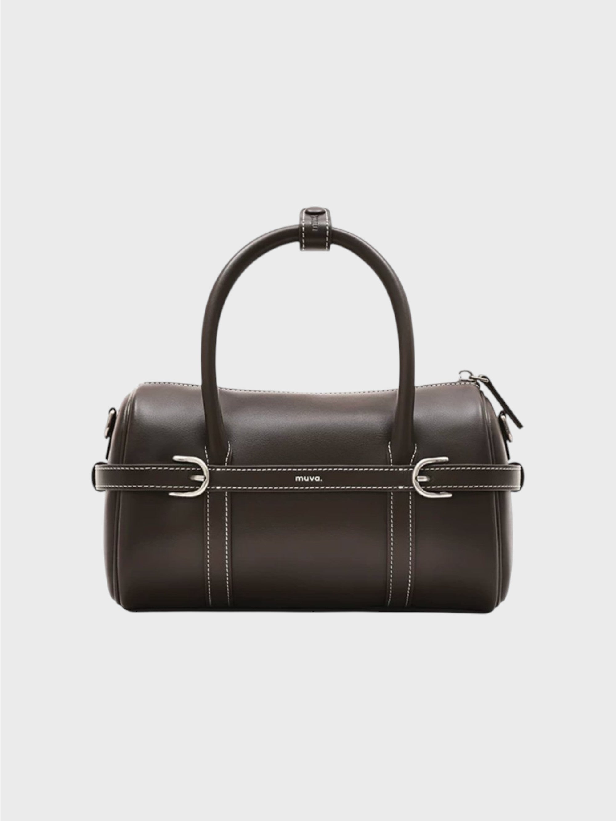 Sac boston MUVA cuir véritable marron foncé avec surpiqûres blanches, sangle centrale boucles D argentées et logo MUVA gravé, anse arrondie rigide, vue de face fond gris
