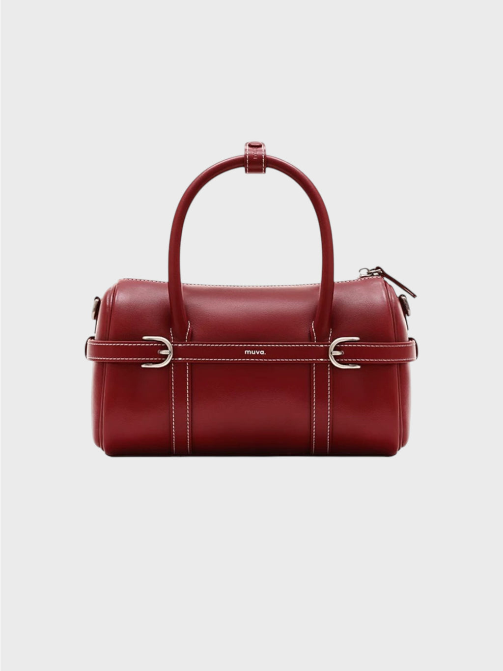 Sac boston MUVA cuir véritable rouge bordeaux avec surpiqûres blanches, sangle centrale boucles D argentées et logo MUVA gravé, anse arrondie rigide, vue de face fond gris
