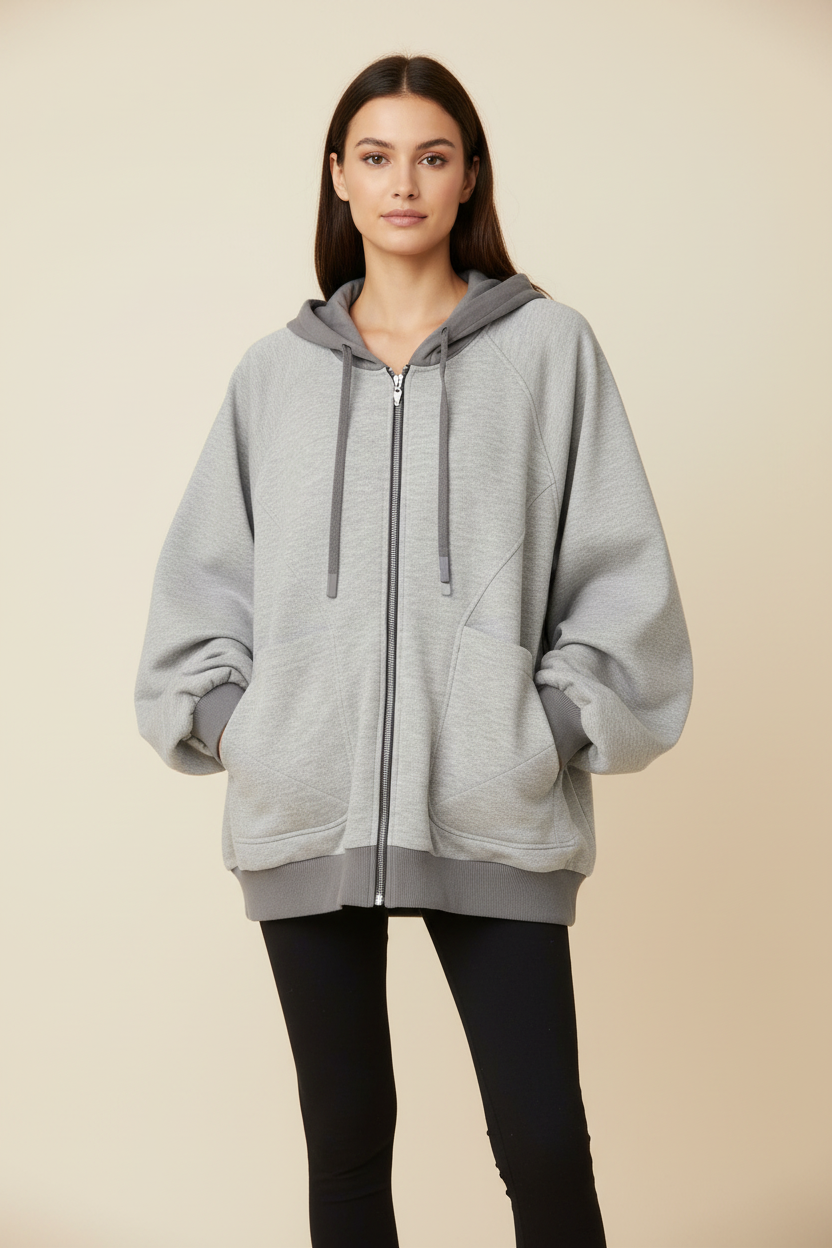 Sweat à capuche zippé oversize Relabel gris chiné coton molleton cordons gris poches kangourou, porté par un modèle femme vue de face fond beige studio