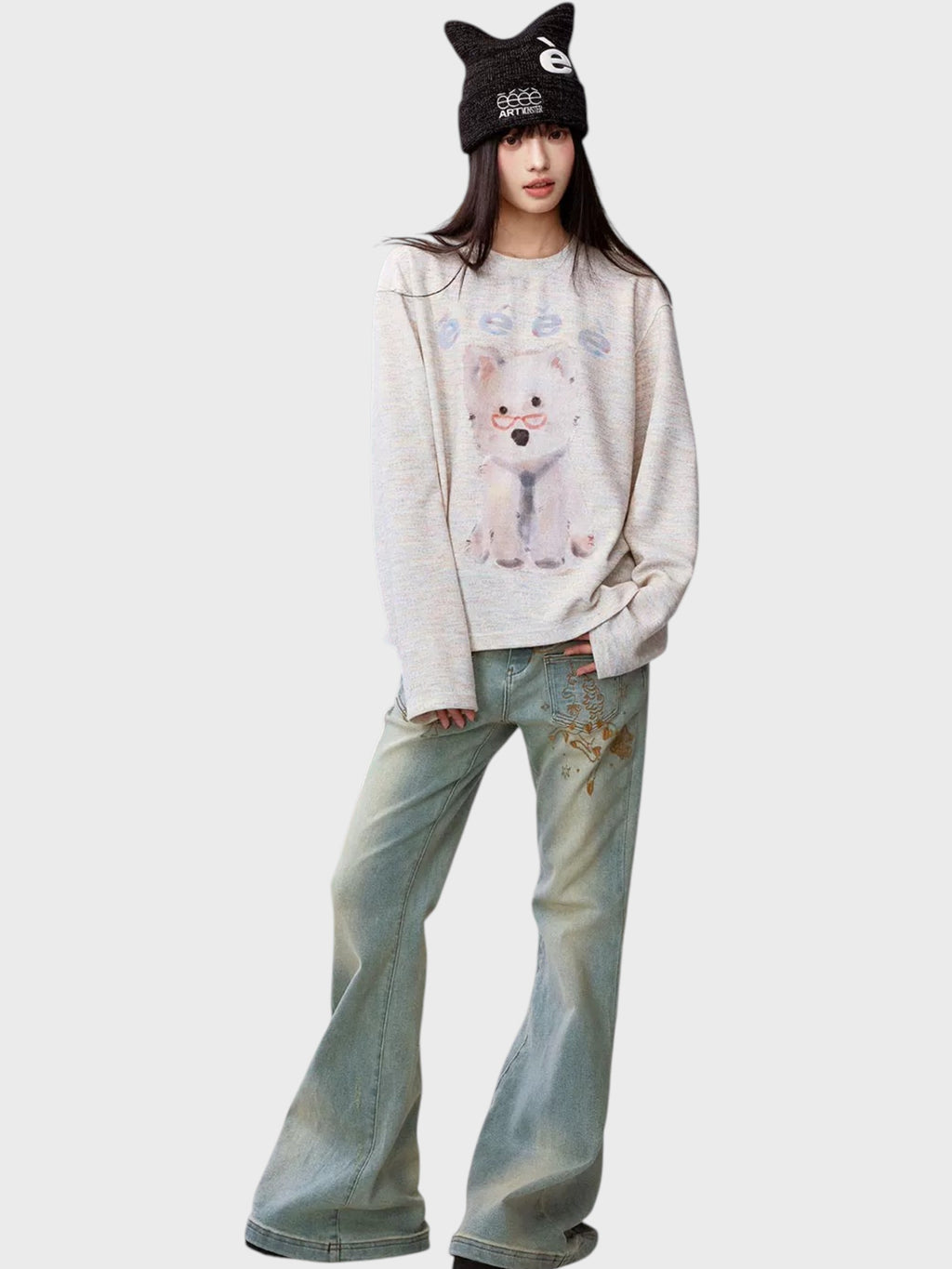 Sweat manches longues eeee Artmonster chiot lunettes porté par une femme, look complet avec jean évasé washed et bonnet chat eeee
