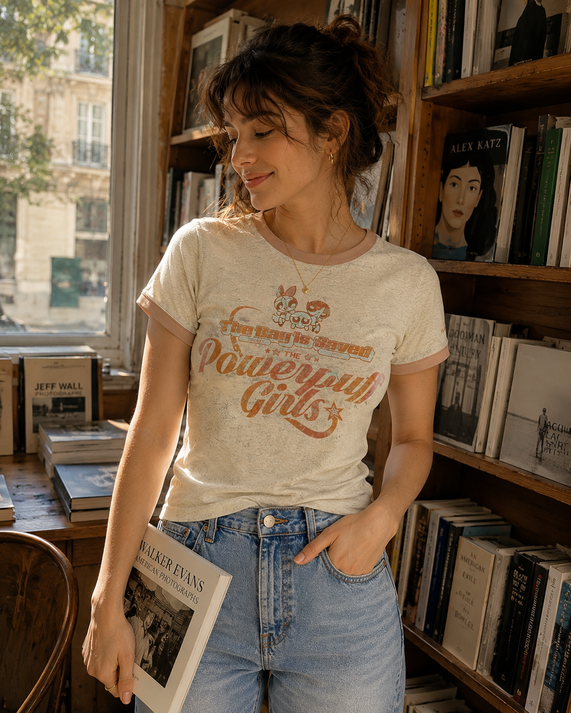 T-shirt ajusté BJHG motif Powerpuff Girls vintage en beige chiné, porté par une femme debout dans une librairie, vue de face