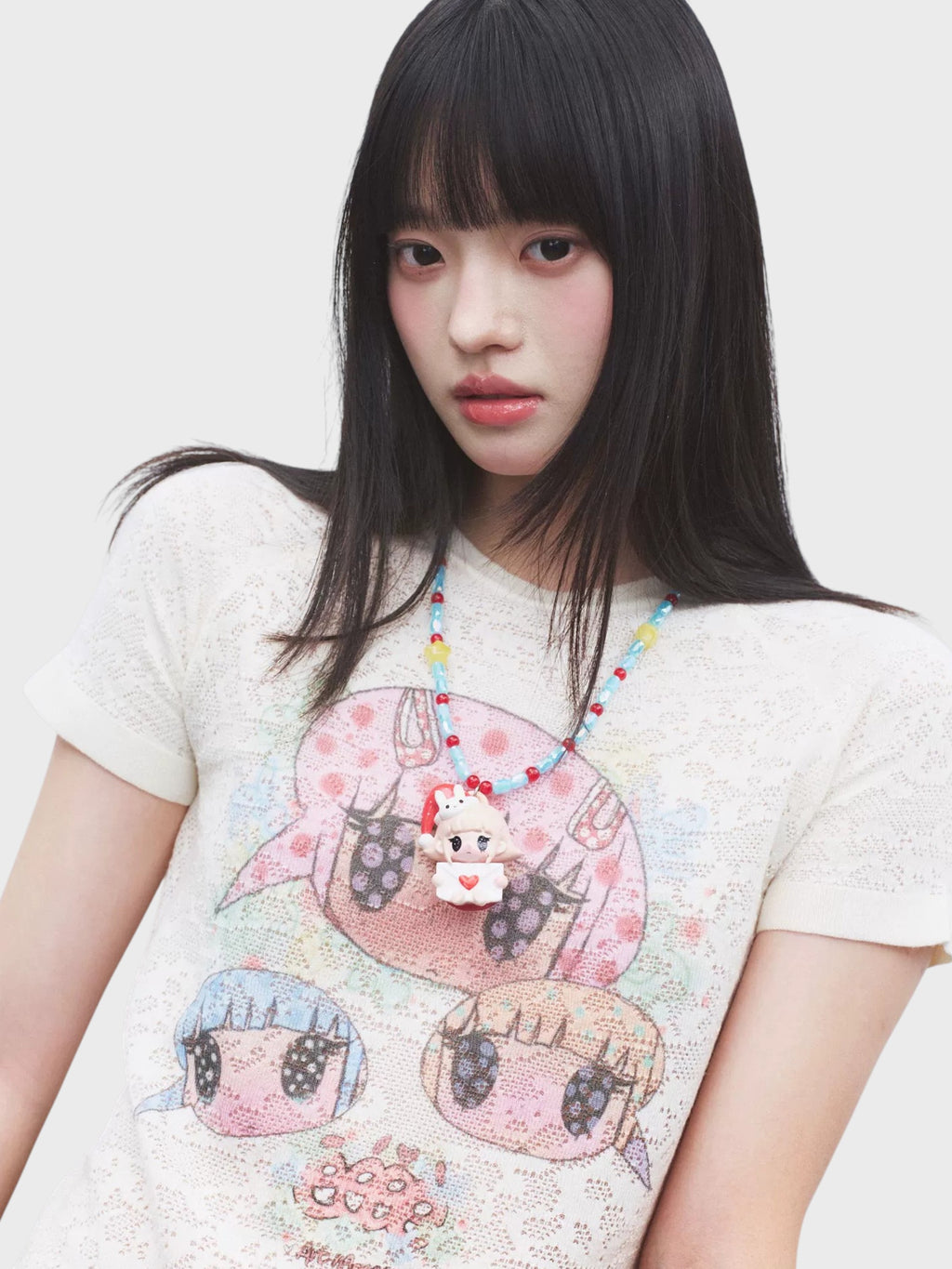 T-shirt manches courtes tricot ajouré eeee Artmonster porté par une femme, gros plan sur l'imprimé manga avec collier perles
