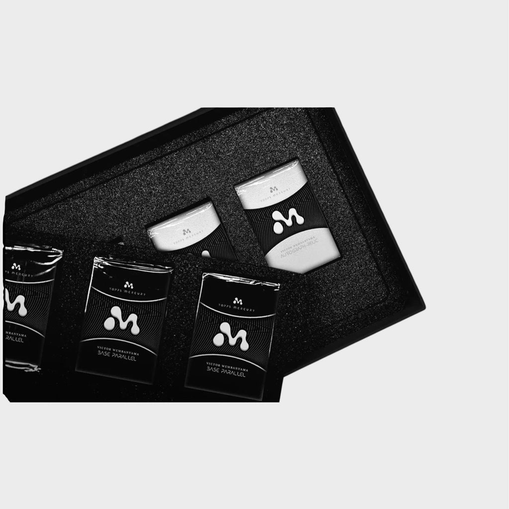 Topps Mercury Victor Wembanyama coffret ouvert révélant les packs de cartes Base Parallel et cartes à collectionner NBA dans un écrin noir, vue de dessus
